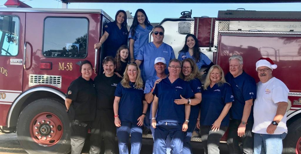 A group in blue shirts in front of a fire engine