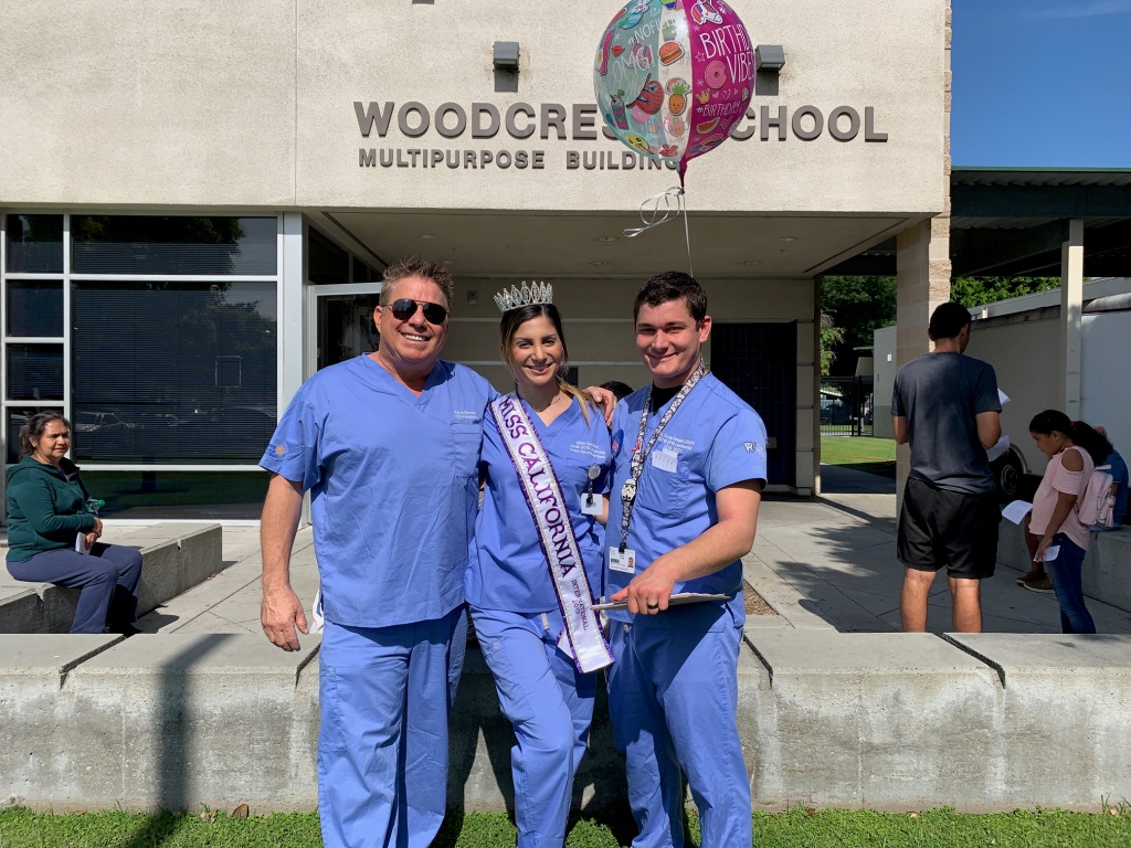 Volunteers in blue scrubs outside Woodcrest School